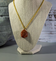 Finished and shaped red Aventurine rock necklace, with intriguing shape and cream and light brown accents