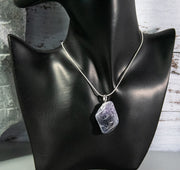 Unfinished Amethyst rock necklace with multitude of dark blue accents and intrusions