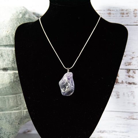 Unfinished Amethyst rock necklace with multitude of dark blue accents and intrusions